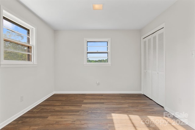 unfurnished bedroom with baseboards, a closet, and wood finished floors