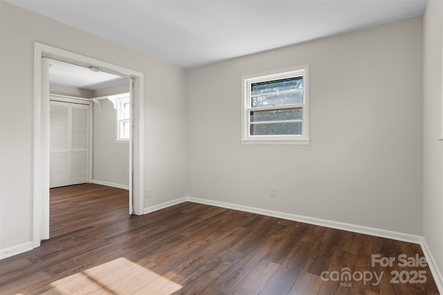 unfurnished bedroom featuring baseboards and dark wood-style floors