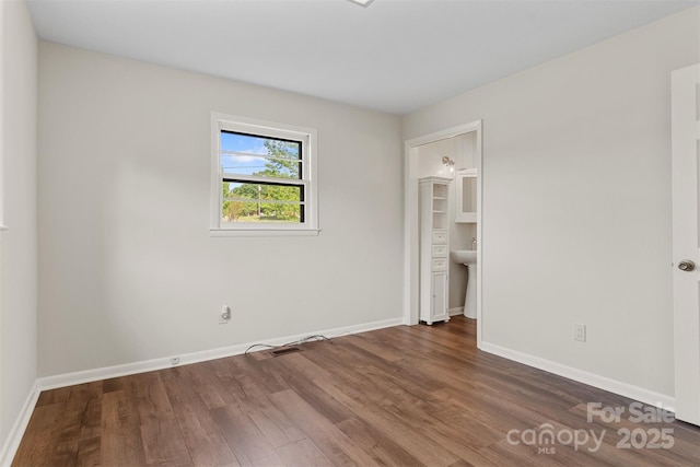 unfurnished bedroom with baseboards and wood finished floors