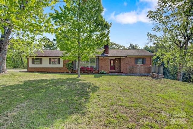 rear view of property with a chimney, a yard, a deck, and brick siding