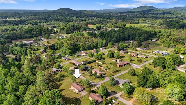 birds eye view of property featuring a mountain view and a wooded view