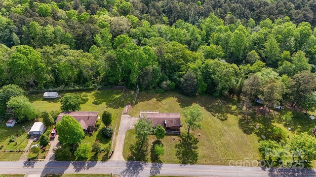 birds eye view of property featuring a view of trees