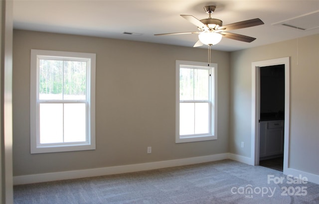unfurnished bedroom with baseboards, ensuite bathroom, visible vents, and light carpet
