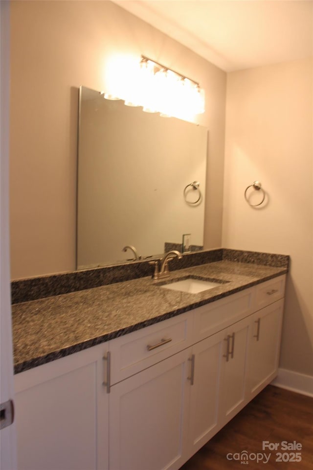bathroom featuring vanity, baseboards, and wood finished floors