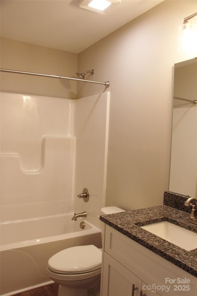 full bathroom with toilet, bathing tub / shower combination, wood finished floors, and vanity