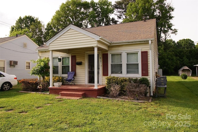 615 Mauney Ave, Kings Mountain, NC 28086 - bungalow featuring a front yard, roof with shingles, a porch, and a wall mounted AC