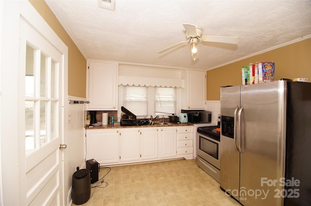 615 Mauney Ave, Kings Mountain, NC 28086 - kitchen with a textured ceiling, white cabinets, appliances with stainless steel finishes, dark countertops, and a healthy amount of sunlight