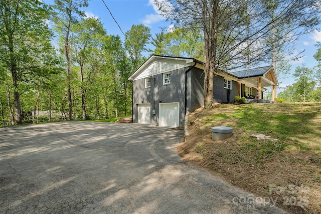 75 White Pine Dr, Fletcher, NC 28732 - view of property exterior featuring a garage, aphalt driveway, covered porch, and metal roof