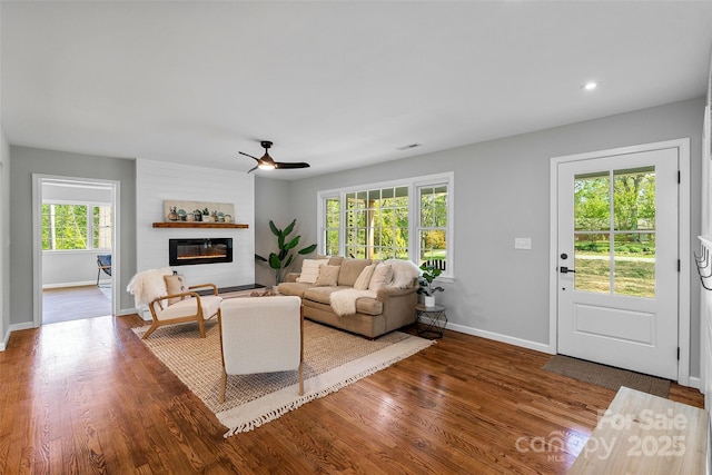 75 White Pine Dr, Fletcher, NC 28732 - living room featuring a ceiling fan, visible vents, wood finished floors, baseboards, and a glass covered fireplace