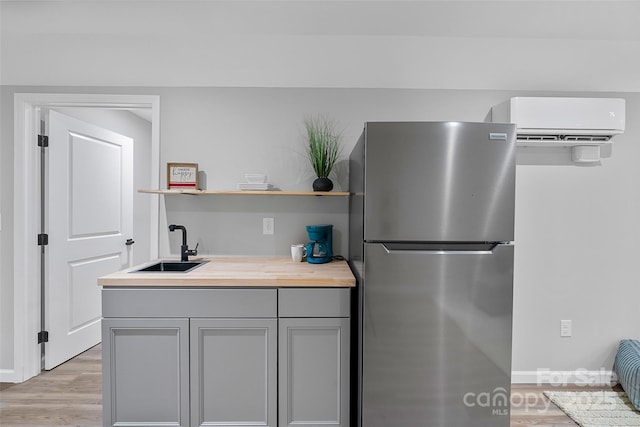 75 White Pine Dr, Fletcher, NC 28732 - kitchen with freestanding refrigerator, open shelves, gray cabinets, a wall mounted AC, and a sink