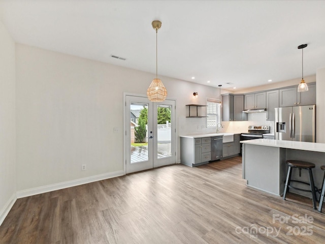 240 Faust Rd, Davidson, NC 28036 - kitchen featuring stainless steel appliances, gray cabinets, light countertops, wood finished floors, and pendant lighting