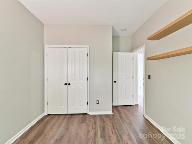 240 Faust Rd, Davidson, NC 28036 - unfurnished bedroom with wood finished floors, a closet, and baseboards
