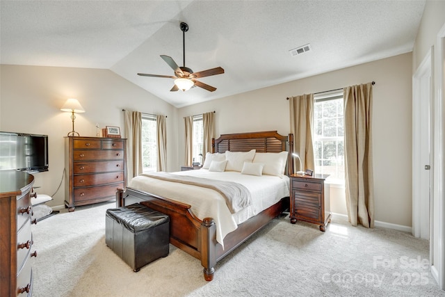 carpeted bedroom with visible vents, a ceiling fan, multiple windows, and lofted ceiling