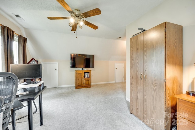 interior space with lofted ceiling, visible vents, baseboards, light carpet, and a ceiling fan