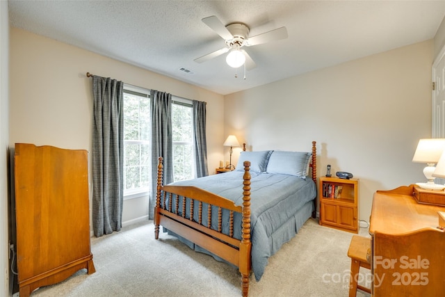 carpeted bedroom featuring baseboards, visible vents, and a ceiling fan