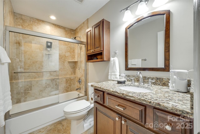 full bathroom with toilet, vanity, and shower / bath combination with glass door