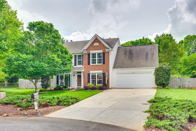 colonial inspired home featuring concrete driveway, a front yard, an attached garage, and fence