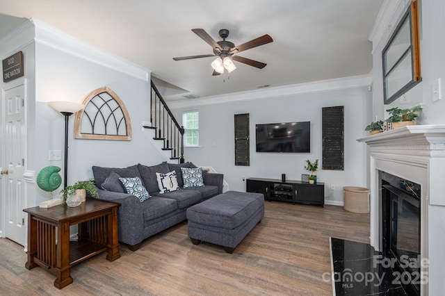 7905 Sedgebrook Dr E, Stanley, NC 28164 - living room featuring wood finished floors, ceiling fan, stairs, ornamental molding, and a high end fireplace