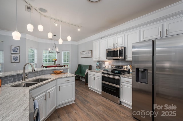 7905 Sedgebrook Dr E, Stanley, NC 28164 - kitchen featuring stainless steel appliances, a sink, track lighting, white cabinets, and decorative backsplash