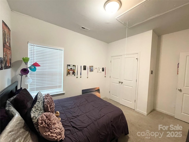 bedroom featuring light colored carpet, attic access, baseboards, visible vents, and a closet