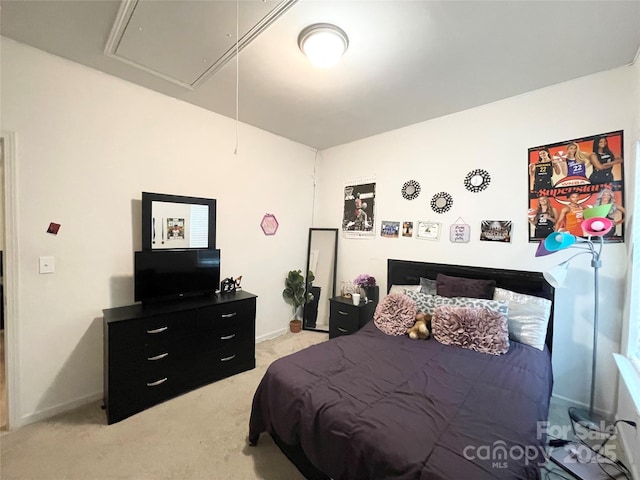 bedroom featuring baseboards, light colored carpet, and attic access