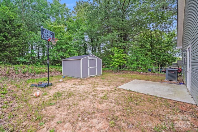view of yard featuring cooling unit, an outbuilding, a patio area, and a storage unit