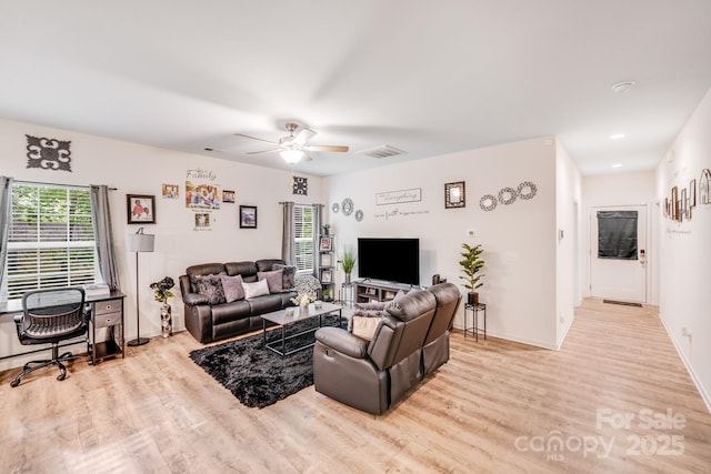 living area with baseboards, ceiling fan, wood finished floors, and visible vents