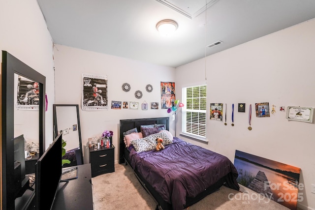 bedroom featuring visible vents, light carpet, and attic access
