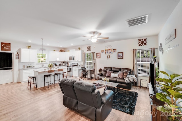living room featuring recessed lighting, ceiling fan, light wood finished floors, and visible vents