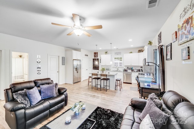 living room with recessed lighting, ceiling fan, visible vents, and light wood finished floors