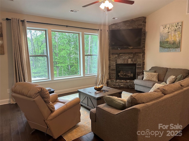 living area featuring a fireplace, a ceiling fan, visible vents, baseboards, and hardwood / wood-style flooring