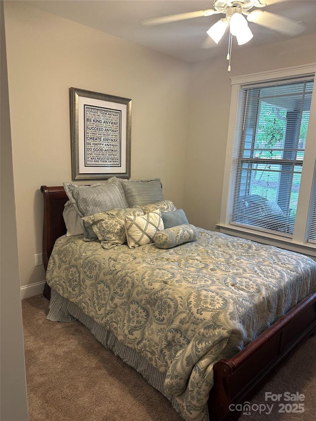 carpeted bedroom with ceiling fan and baseboards