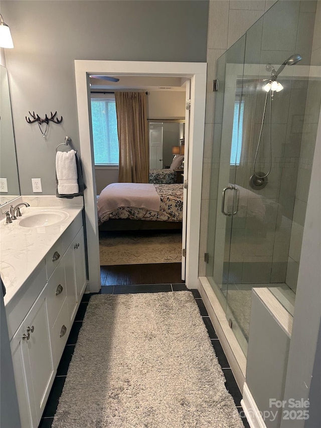 full bath with a stall shower, vanity, tile patterned floors, and ensuite bathroom