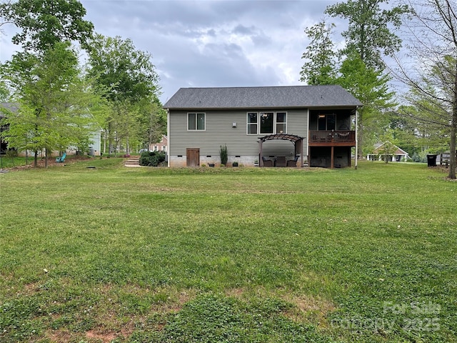 rear view of house featuring a lawn, crawl space, and a wooden deck