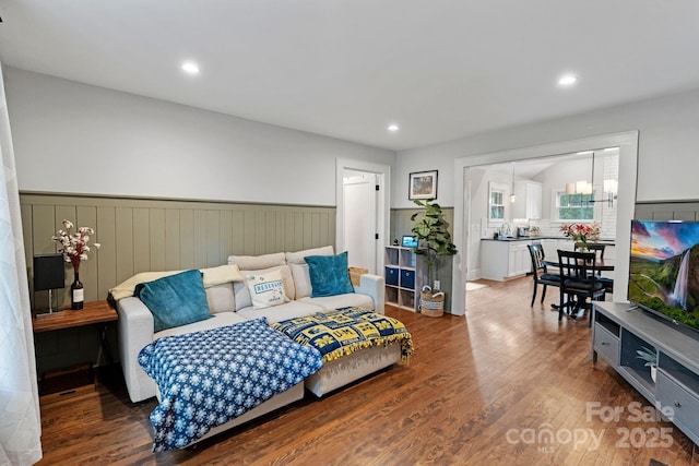 bedroom featuring recessed lighting, a wainscoted wall, a sink, and wood finished floors