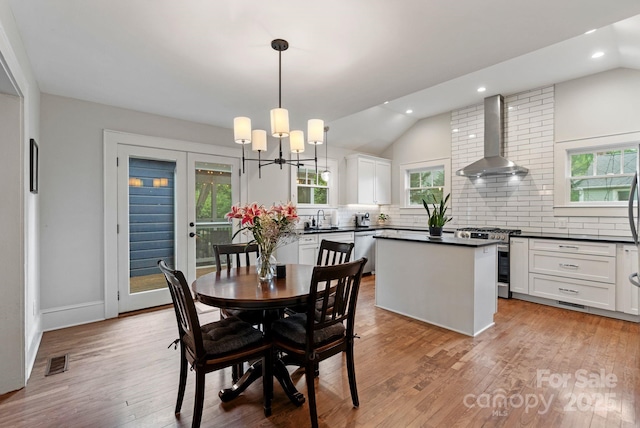 dining space with recessed lighting, visible vents, lofted ceiling, and light wood-style floors