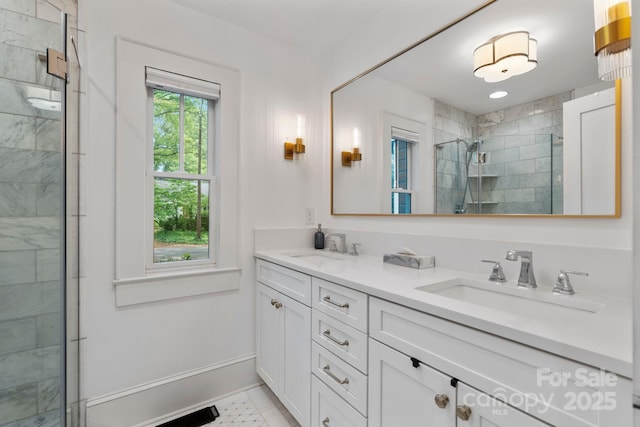 bathroom featuring double vanity, a shower stall, baseboards, and a sink