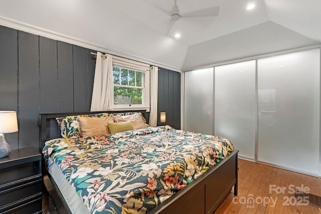 bedroom featuring lofted ceiling, light wood-style floors, a closet, recessed lighting, and a ceiling fan