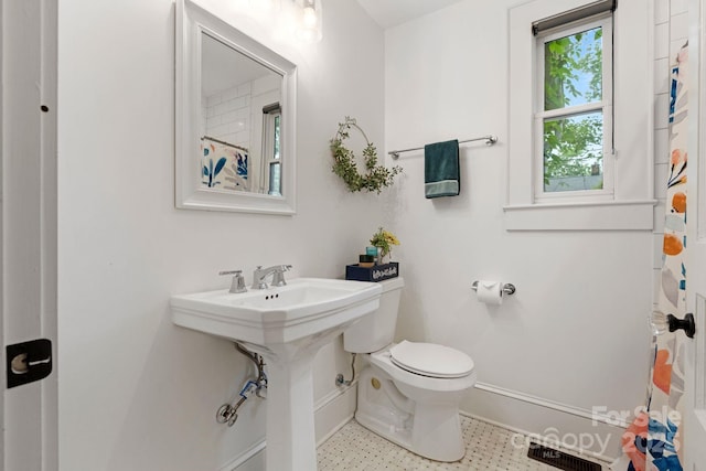 bathroom with visible vents, toilet, a shower with shower curtain, and baseboards