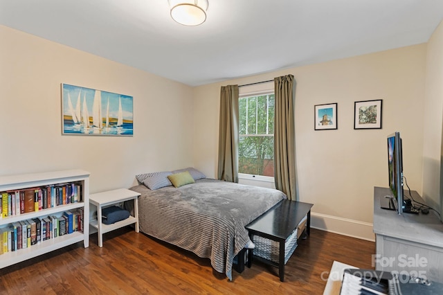 bedroom with wood finished floors and baseboards