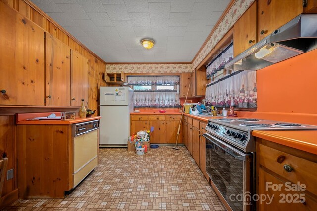 kitchen featuring electric range, brown cabinetry, freestanding refrigerator, under cabinet range hood, and dishwashing machine