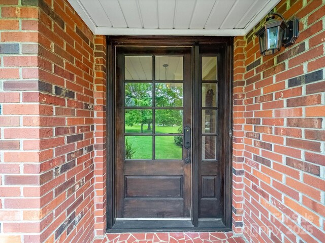 view of exterior entry with brick siding