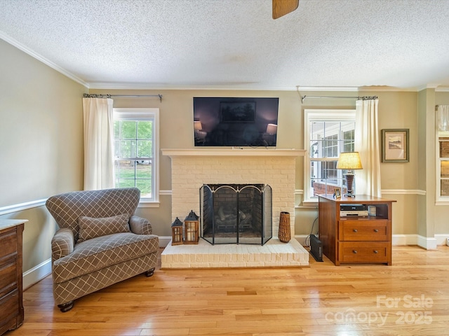living area with crown molding, a textured ceiling, and wood finished floors