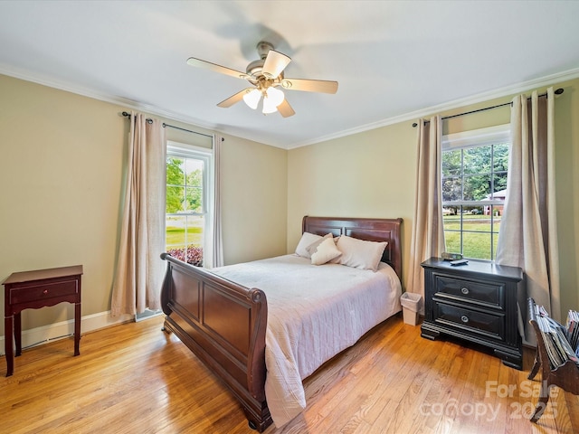 bedroom featuring light wood finished floors, a ceiling fan, ornamental molding, and baseboards