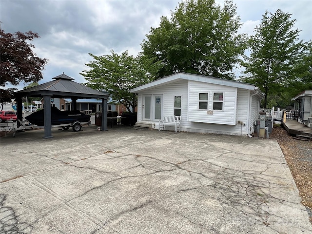 view of front facade with concrete driveway, entry steps, a gazebo, and a detached carport