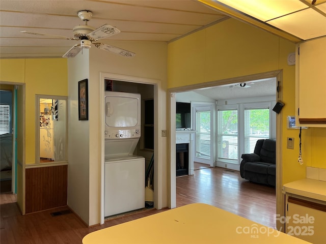 bedroom with stacked washing maching and dryer, wood finished floors, and a fireplace