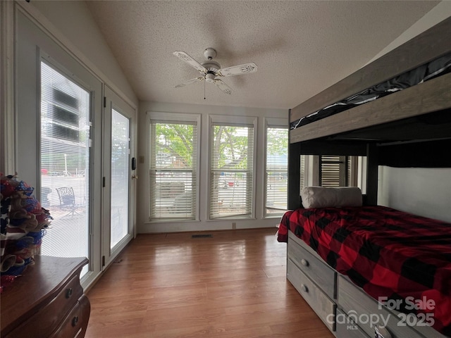 bedroom with access to outside, a textured ceiling, ceiling fan, and light wood-type flooring