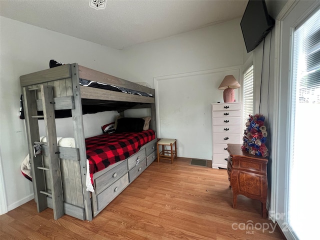 bedroom with visible vents and light wood-style flooring