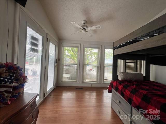 bedroom featuring ceiling fan, access to outside, light wood-style flooring, and a textured ceiling