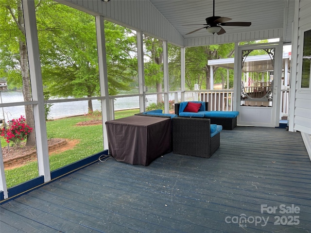 unfurnished sunroom featuring a water view, ceiling fan, and a healthy amount of sunlight